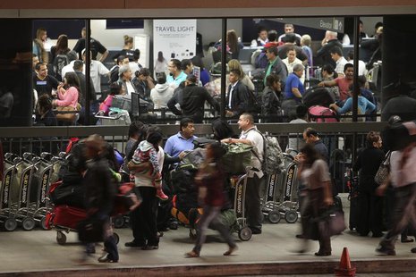 People line up at Terminal 2 ticket counters as access to airport terminal parking lots resumes at Los Angeles International Airport, Califo People line up at Terminal 2 ticket counters as access to airport terminal parking lots resumes at Los Angeles International Airport, Califo