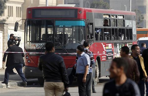A member of the media films a damaged bus after a bomb blast near the Al-Azhar University campus in Cairo's Nasr City district December 26, A member of the media films a damaged bus after a bomb blast near the Al-Azhar University campus in Cairo's Nasr City district December 26,