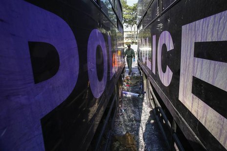 A Thai security personnel inspects destroyed police trucks at the Thai-Japan youth stadium, the site of fierce clashes between anti-governme A Thai security personnel inspects destroyed police trucks at the Thai-Japan youth stadium, the site of fierce clashes between anti-governme