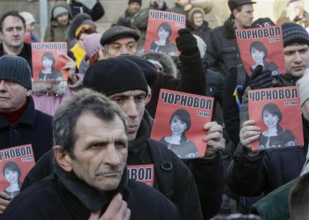 Protesters hold pictures of journalist Tetyana Chornovil, who was beaten and left in a ditch just hours after publishing an article on the a Protesters hold pictures of journalist Tetyana Chornovil, who was beaten and left in a ditch just hours after publishing an article on the a