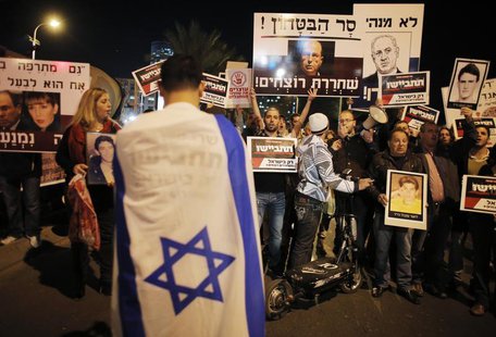 An Israeli demonstrator with an Israeli flag wrapped around himself takes part in a protest against the upcoming release of Palestinian pris An Israeli demonstrator with an Israeli flag wrapped around himself takes part in a protest against the upcoming release of Palestinian pris