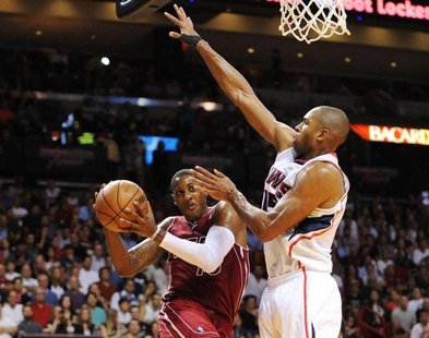 Dec 23, 2013; Miami, FL, USA; Miami Heat point guard Mario Chalmers (15) is defended by Atlanta Hawks center Al Horford (15) under the baske Dec 23, 2013; Miami, FL, USA; Miami Heat point guard Mario Chalmers (15) is defended by Atlanta Hawks center Al Horford (15) under the baske