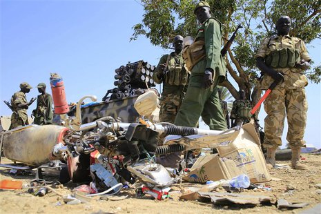South Sudan army soldiers stand next to a destroyed motorcycle near Bor Airport, 180 km (108 miles) northwest from capital Juba December 25, South Sudan army soldiers stand next to a destroyed motorcycle near Bor Airport, 180 km (108 miles) northwest from capital Juba December 25,