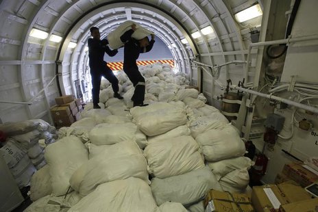 Members of the Philippine Navy carry a sack containing relief goods before transporting them to the battered town of Tacloban city, central Members of the Philippine Navy carry a sack containing relief goods before transporting them to the battered town of Tacloban city, central