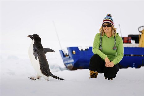 Barbara Tucker, a passenger aboard the trapped ship MV Akademik Shokalskiy looks at an Adelie penguin walking by on the ice off East Antarct Barbara Tucker, a passenger aboard the trapped ship MV Akademik Shokalskiy looks at an Adelie penguin walking by on the ice off East Antarct