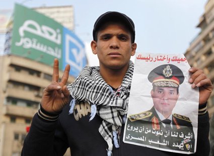 A supporter of Egypt's army chief and defense minister General Abdel Fattah al-Sisi holds a poster with Sisi's image during a protest in sup A supporter of Egypt's army chief and defense minister General Abdel Fattah al-Sisi holds a poster with Sisi's image during a protest in sup