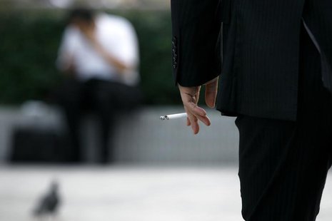 A man holds a cigarette in Tokyo August 3, 2009. REUTERS/Stringer A man holds a cigarette in Tokyo August 3, 2009. REUTERS/Stringer