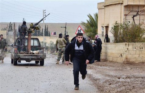 A man runs as a Free Syrian Army fighter stands on a back of a truck after what activists said were clashes between the Free Syrian Army and A man runs as a Free Syrian Army fighter stands on a back of a truck after what activists said were clashes between the Free Syrian Army and