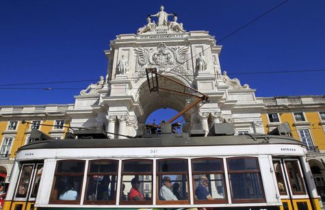 Passengers inside a tram pass in front of the main arch of Praca do Comercio square where the Finance Ministry is located, in Lisbon Septemb Passengers inside a tram pass in front of the main arch of Praca do Comercio square where the Finance Ministry is located, in Lisbon Septemb