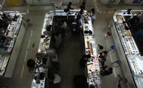Sales people negotiate with customers at booths selling mobile phones at a shopping mall in Beijing September 3, 2013. REUTERS/Kim Kyung-Hoo Sales people negotiate with customers at booths selling mobile phones at a shopping mall in Beijing September 3, 2013. REUTERS/Kim Kyung-Hoo