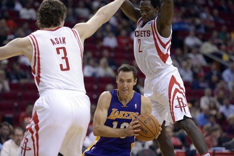 Los Angeles Lakers point guard Steve Nash (10) drives against Houston Rockets center Omer Asik (3) and point guard Patrick Beverley (2) duri Los Angeles Lakers point guard Steve Nash (10) drives against Houston Rockets center Omer Asik (3) and point guard Patrick Beverley (2) duri
