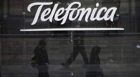 People are reflected as they walk past Spanish telecom group Telefonica's flagship store in central Madrid November 8, 2013. REUTERS/Sergio People are reflected as they walk past Spanish telecom group Telefonica's flagship store in central Madrid November 8, 2013. REUTERS/Sergio
