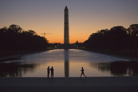A couple (L) and a jogger pass by the Lincoln Memorial Reflecting Pool before sunrise in Washington, September 24, 2013. REUTERS/Jason Reed A couple (L) and a jogger pass by the Lincoln Memorial Reflecting Pool before sunrise in Washington, September 24, 2013. REUTERS/Jason Reed