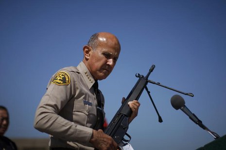 Los Angeles County Sheriff Lee Baca holds a .308 caliber semi-automatic rifle to be melted at the Los Angeles County Sheriff's Department's Los Angeles County Sheriff Lee Baca holds a .308 caliber semi-automatic rifle to be melted at the Los Angeles County Sheriff's Department's