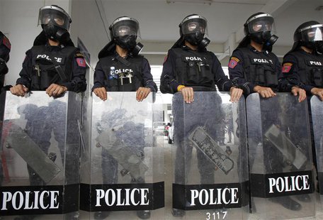 Riot police officers, wearing gas masks, stand with their shields during a demonstration for the media at the Royal Thai Police Sport Club i Riot police officers, wearing gas masks, stand with their shields during a demonstration for the media at the Royal Thai Police Sport Club i