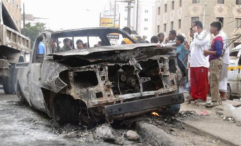 People gather around the vehicle of a Yemeni intelligence officer that was destroyed by a blast from an explosive device in the southern Yem People gather around the vehicle of a Yemeni intelligence officer that was destroyed by a blast from an explosive device in the southern Yem