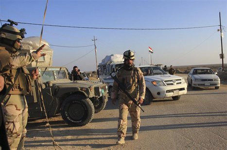 Iraqi soldiers stand guard at a checkpoint in Ein Tamarm, a town some 40 km (25 miles) west of Kerbala, January 7, 2014. REUTERS/Mushtaq Muh Iraqi soldiers stand guard at a checkpoint in Ein Tamarm, a town some 40 km (25 miles) west of Kerbala, January 7, 2014. REUTERS/Mushtaq Muh