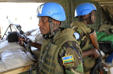 Soldiers from Rwanda serving under United Nations Mission in South Sudan (UNAMISS) hold their weapons as they keep watch from an observatory Soldiers from Rwanda serving under United Nations Mission in South Sudan (UNAMISS) hold their weapons as they keep watch from an observatory