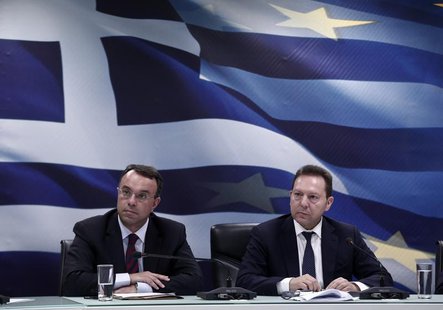 Greece's Finance Minister Yannis Stournaras (R) and Deputy Finance Minister Christos Staikouras listen to questions during a news briefing r Greece's Finance Minister Yannis Stournaras (R) and Deputy Finance Minister Christos Staikouras listen to questions during a news briefing r