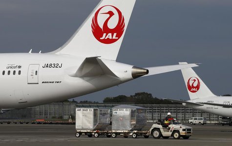 A airport worker drives a luggage transport vehicle past one of the company's Boeing Co's 787 Dreamliner plane (L) and a Beoing 767 at Narit A airport worker drives a luggage transport vehicle past one of the company's Boeing Co's 787 Dreamliner plane (L) and a Beoing 767 at Narit