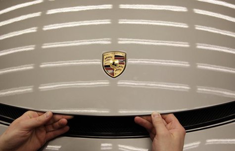 Worker closes engine bonnet of a new Porsche 918-Spyder sports car at the production line of the German car manufacturer's plant in Stuttgar Worker closes engine bonnet of a new Porsche 918-Spyder sports car at the production line of the German car manufacturer's plant in Stuttgar