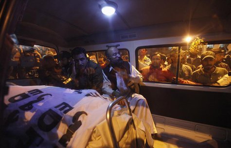 Relatives of Pakistan's Crime Investigation Department (CID) Chief Chaudhry Aslam sit in an ambulance with his body outside Jinnah Postgradu Relatives of Pakistan's Crime Investigation Department (CID) Chief Chaudhry Aslam sit in an ambulance with his body outside Jinnah Postgradu