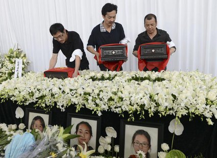 The fathers of Liu Yipeng, Wang Linjia and Ye Mengyuan, the three girls who died in the Asiana Airlines crash, carry the ashes of their daug The fathers of Liu Yipeng, Wang Linjia and Ye Mengyuan, the three girls who died in the Asiana Airlines crash, carry the ashes of their daug