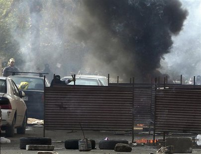 Supporters of ousted Egyptian president Mohamed Mursi hide behind barricades, as black smoke billows from burning tyres, during clashes with Supporters of ousted Egyptian president Mohamed Mursi hide behind barricades, as black smoke billows from burning tyres, during clashes with