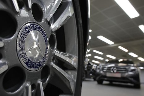 A company logo is seen on a wheel in front of Mercedes-Benz A-class cars displayed in a dealership of German car manufacturer Daimler in Par A company logo is seen on a wheel in front of Mercedes-Benz A-class cars displayed in a dealership of German car manufacturer Daimler in Par