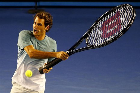 Roger Federer of Switzerland hits a ball with an oversized tennis racquet during the Kids Tennis Day before the Australian Open 2014 tennis Roger Federer of Switzerland hits a ball with an oversized tennis racquet during the Kids Tennis Day before the Australian Open 2014 tennis