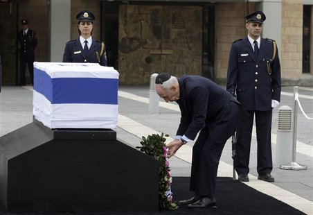 Israel's President Shimon Peres (C) lays a wreath near the flag draped coffin of former Israeli prime minister Ariel Sharon as he lies in st Israel's President Shimon Peres (C) lays a wreath near the flag draped coffin of former Israeli prime minister Ariel Sharon as he lies in st