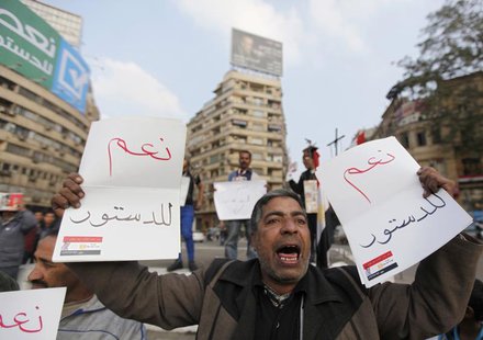 A supporter of Egypt's army chief and defense minister General Abdel Fattah al-Sisi holds signs during a protest in support of the new const A supporter of Egypt's army chief and defense minister General Abdel Fattah al-Sisi holds signs during a protest in support of the new const