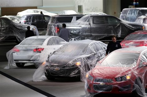 Vehicles are covered with protective wrap as workers prepare the General Motors automakers display ahead of the media preview of the North A Vehicles are covered with protective wrap as workers prepare the General Motors automakers display ahead of the media preview of the North A