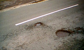 Potholes are caused by freezing and thawing in the pavement which causes cracks and is then pounded by cars and trucks opening up chasms. Potholes are caused by freezing and thawing in the pavement which causes cracks and is then pounded by cars and trucks opening up chasms.