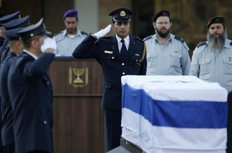 A member of the Knesset guard salutes near the flag draped coffin of former Israeli prime minister Ariel Sharon before a memorial ceremony a A member of the Knesset guard salutes near the flag draped coffin of former Israeli prime minister Ariel Sharon before a memorial ceremony a