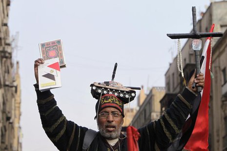 A supporter of Egypt's army chief and defense minister General Abdel Fattah al-Sisi holds a Koran (L) and a cross during a protest in suppor A supporter of Egypt's army chief and defense minister General Abdel Fattah al-Sisi holds a Koran (L) and a cross during a protest in suppor