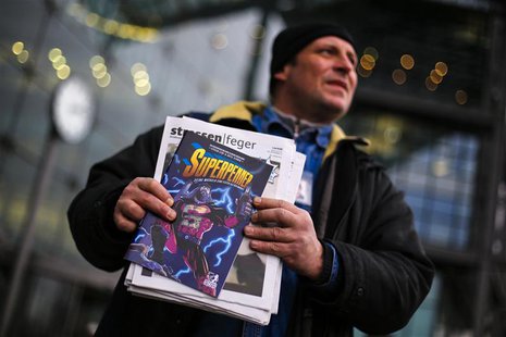 Unemployed street newspaper vendor Karsten offers the Strassenfeger (Street Sweeper) street newspaper and its Superhobo comic supplement in Unemployed street newspaper vendor Karsten offers the Strassenfeger (Street Sweeper) street newspaper and its Superhobo comic supplement in