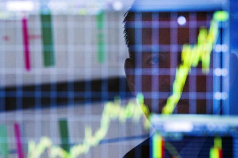 A trader looks up at a chart on his computer screen while working on the floor of the New York Stock Exchange shortly after the market openi A trader looks up at a chart on his computer screen while working on the floor of the New York Stock Exchange shortly after the market openi