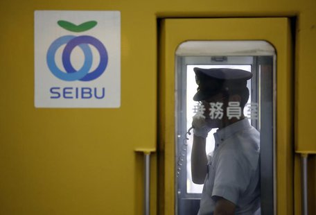 A crewman works inside a train coach of Seibu Railway Co., railway service unit of Seibu Holdings, at a station in Tokyo June 25, 2013. REUT A crewman works inside a train coach of Seibu Railway Co., railway service unit of Seibu Holdings, at a station in Tokyo June 25, 2013. REUT