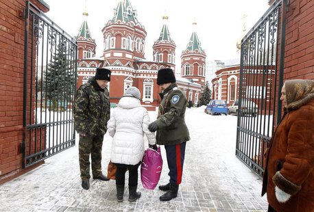 Russian Cossacks, who started regular patrols within the city in the wake of recent suicide attacks, check a woman's belongings in front of Russian Cossacks, who started regular patrols within the city in the wake of recent suicide attacks, check a woman's belongings in front of