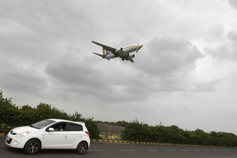 A car moves against the backdrop of a Jet Airways aircraft preparing to land at the airport in the western Indian city of Ahmedabad August 8 A car moves against the backdrop of a Jet Airways aircraft preparing to land at the airport in the western Indian city of Ahmedabad August 8
