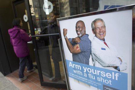 People enter a pharmacy next to a sign promoting flu shots in New York January 10, 2013. REUTERS/Andrew Kelly People enter a pharmacy next to a sign promoting flu shots in New York January 10, 2013. REUTERS/Andrew Kelly