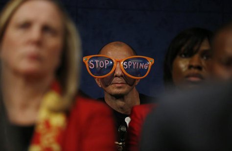 A protester against the practices of U.S. security agenices sits in the audience as U.S. Director of National Intelligence James Clapper, De A protester against the practices of U.S. security agenices sits in the audience as U.S. Director of National Intelligence James Clapper, De