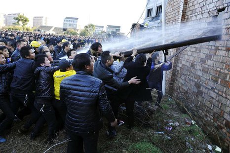 People try to break through the wall for firefighters to extinguish a fire at a factory in Wenling, Zhejiang province, January 14, 2014. REU People try to break through the wall for firefighters to extinguish a fire at a factory in Wenling, Zhejiang province, January 14, 2014. REU