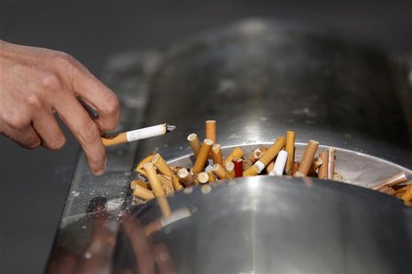 A man flicks ashes from his cigarette over a dustbin in Shanghai January 10, 2014. REUTERS/Aly Song A man flicks ashes from his cigarette over a dustbin in Shanghai January 10, 2014. REUTERS/Aly Song