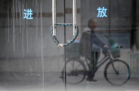 A man rides a bicycle past a closed employment bureau in Dongguan, Guangdong province 13 January, 2014. REUTERS/Alex Lee A man rides a bicycle past a closed employment bureau in Dongguan, Guangdong province 13 January, 2014. REUTERS/Alex Lee