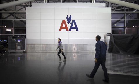 People walk past an American Airlines logo on a wall at John F. Kennedy (JFK) airport in in New York November 27, 2013. REUTERS/Carlo Allegr People walk past an American Airlines logo on a wall at John F. Kennedy (JFK) airport in in New York November 27, 2013. REUTERS/Carlo Allegr