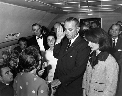 Judge Sarah T. Hughes (L) administers the Presidential Oath of Office to then acting U.S. President Lyndon Baines Johnson (C) aboard Air For Judge Sarah T. Hughes (L) administers the Presidential Oath of Office to then acting U.S. President Lyndon Baines Johnson (C) aboard Air For