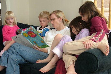 A woman reads to some children. A woman reads to some children.
