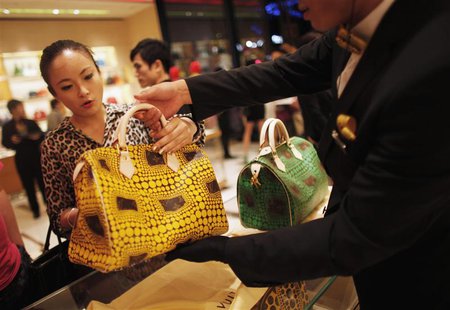 A woman shops in a Louis Vuitton store during Vogue's 4th Fashion's Night Out: Shopping Night with Celebrities in downtown Shanghai in this A woman shops in a Louis Vuitton store during Vogue's 4th Fashion's Night Out: Shopping Night with Celebrities in downtown Shanghai in this